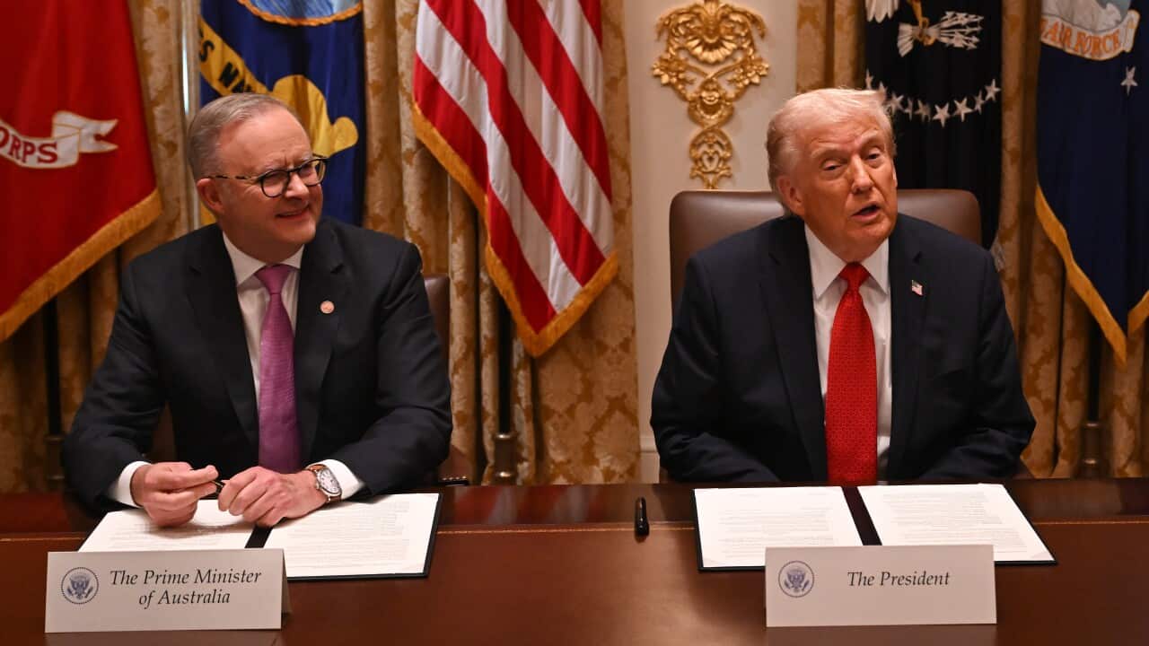 Anthony Albanese and Donald Trump sitting side by side at a table smiling.