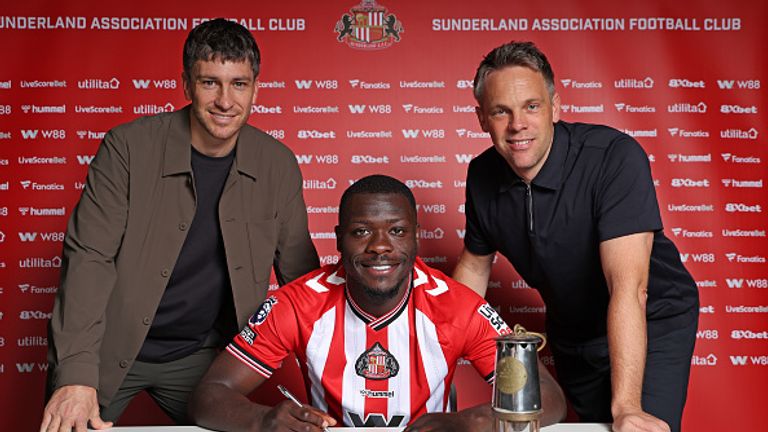 SUNDERLAND, ENGLAND - SEPTEMBER 2: Brian Bobbery poses for pictures with Director of Football Florent Ghisolfi (L) and Sporting Director Krisjaan Speakman (R) after signing a five year deal for Sunderland at The Academy of Light on September 2, 2025 in Sunderland, England. (Photo by Ian Horrocks/Sunderland AFC via Getty Images)