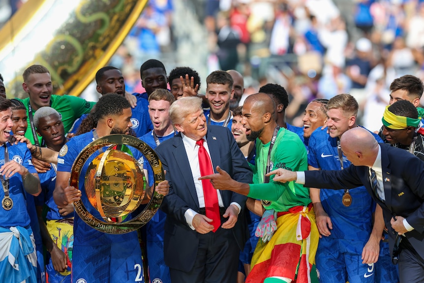 Donald Trump stands among celebrating Chelsea players.